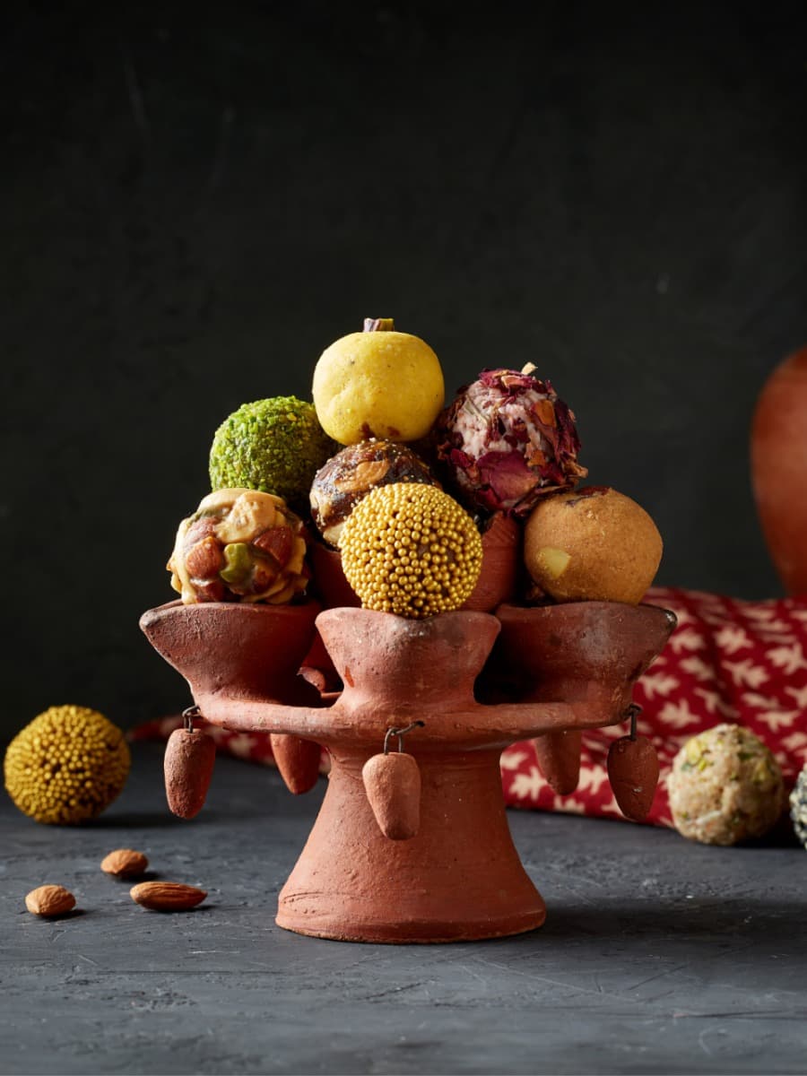 Assorted dry-fruit ladoos on a terracotta stand