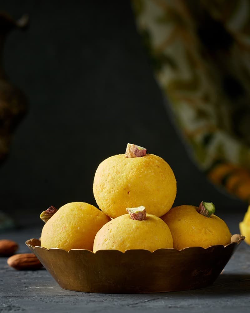 Kesar ladoos in a brass bowl, Diwali still life